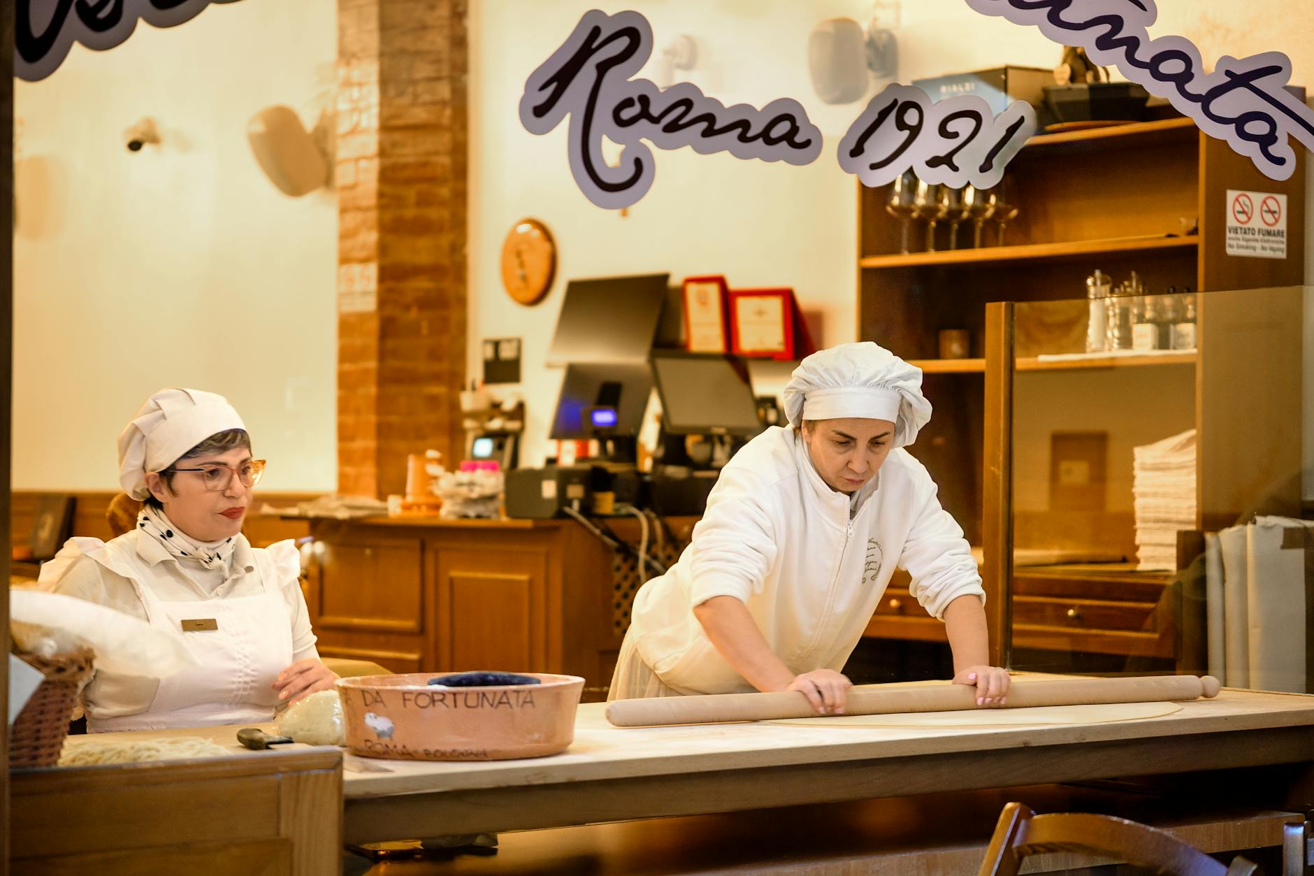 Dwóch kucharzy przygotowuje świeży makaron w tradycyjnej włoskiej kuchni