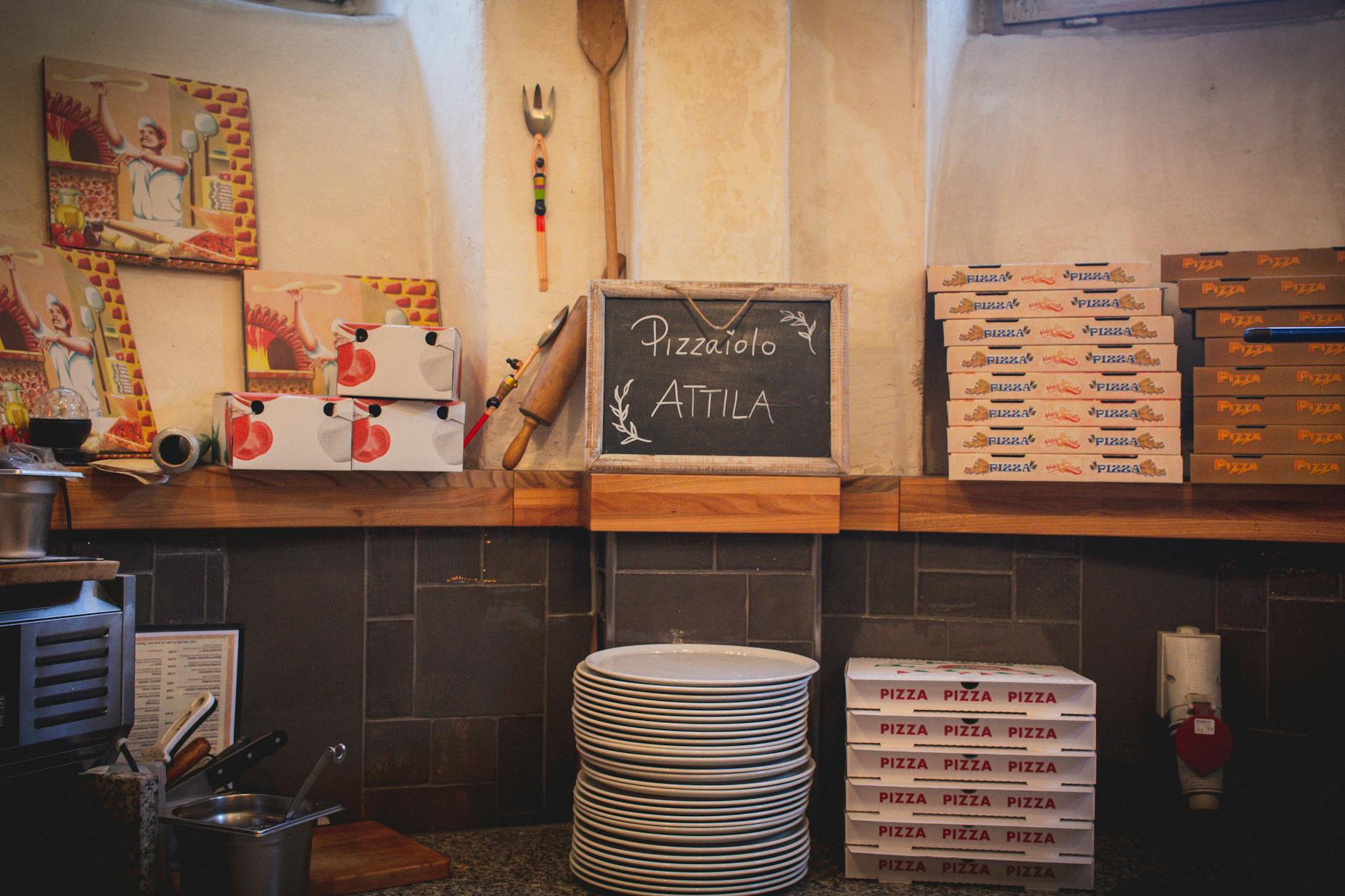 Przytulne wnętrze pizzerii z pudełkami na pizzę i rustykalnym kontuarem