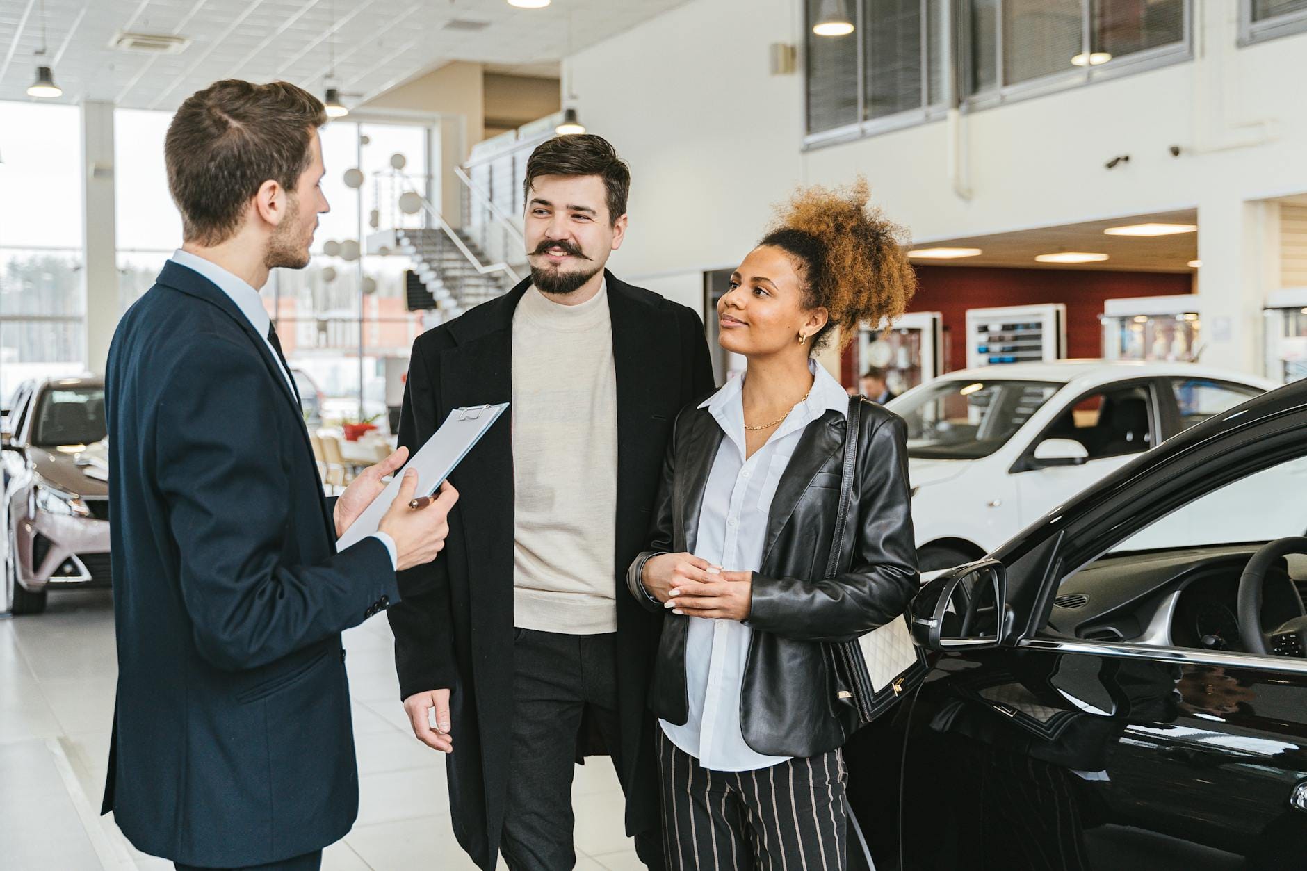 Jak kupić używane auto miejskie do 20 tys. zł – praktyczny poradnik krok po kroku Para rozmawia z doradcą w salonie przy wyborze używanego auta miejskiego
